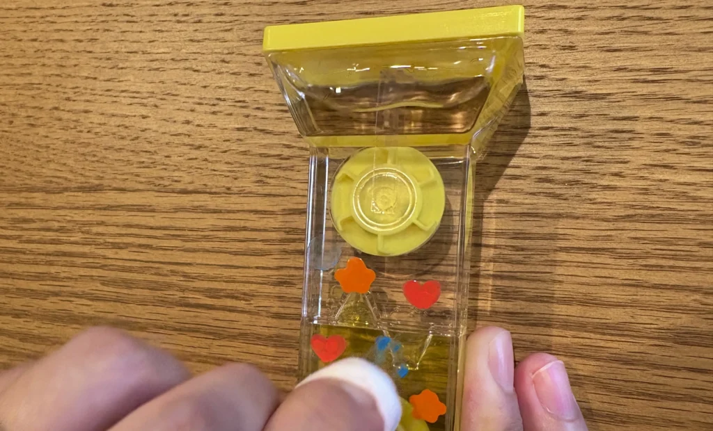 オイルタイマーをペンでデコレーションしたが、失敗してウェットティッシュで拭いている様子