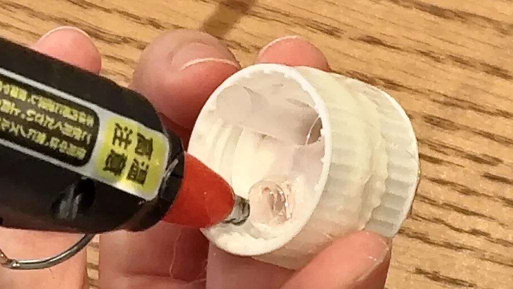 オイルタイマーの自作手順3、ストローを通したら、グルーガンでストローと穴を接着